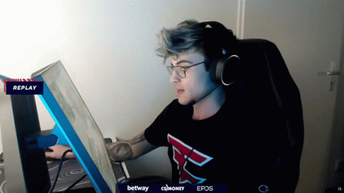 A Man Wearing Headphones And A Shirt With The Letter F On It Looks At A Computer Screen GIF