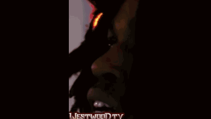 A Man Wearing Headphones And A Superman Shirt Is Standing In Front Of A Microphone With The Words Westwood Tv On The Bot GIF