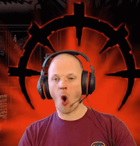 A Man Wearing Headphones And A T-Shirt With The Letter S On It Makes A Funny Face GIF