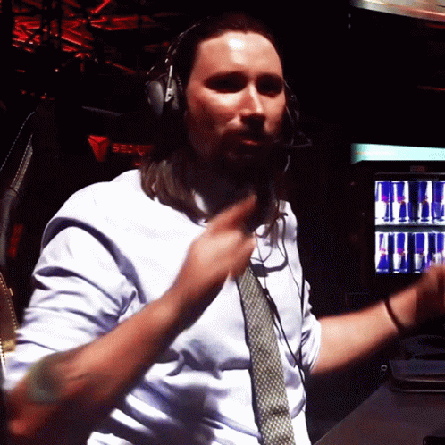 A Man Wearing Headphones And A Tie Is Dancing In Front Of A Red Bull Machine GIF