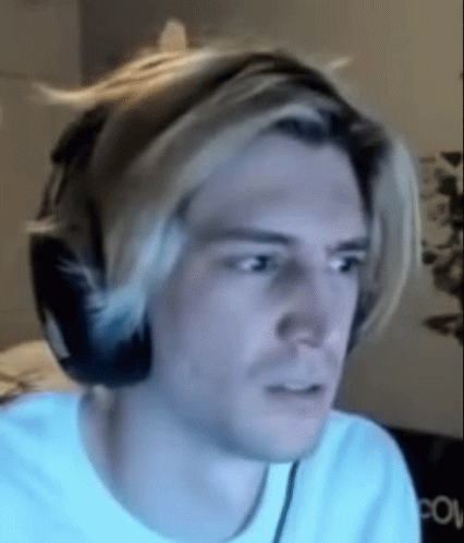 A Man Wearing Headphones And A White Shirt Is Making A Funny Face . GIF