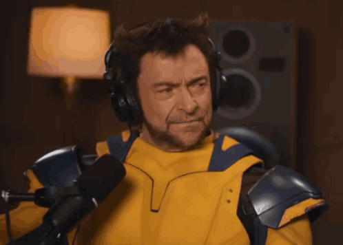 A Man Wearing Headphones And A Yellow Jacket GIF