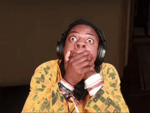 A Man Wearing Headphones And A Yellow Shirt Has A Bracelet On His Wrist That Says I 'M A Troll GIF