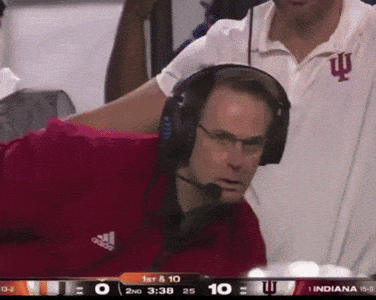 A Man Wearing Headphones And An Adidas Shirt Is Watching A Game GIF