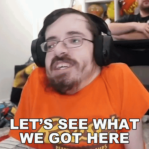 A Man Wearing Headphones And An Orange Shirt With The Words Let 'S See What We Got Here GIF
