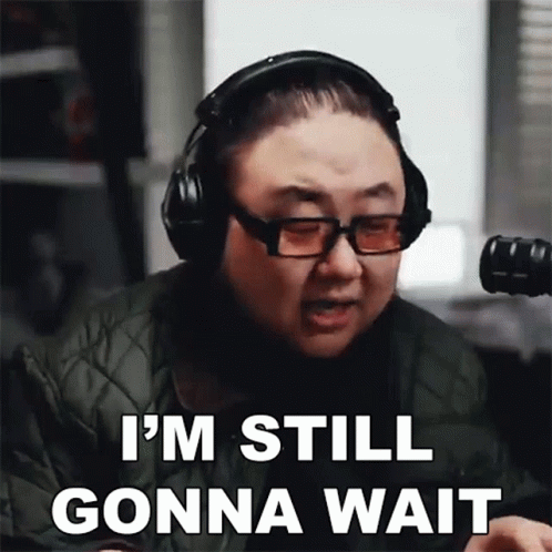 A Man Wearing Headphones And Glasses Is Saying " I 'M Still Gonna Wait " GIF
