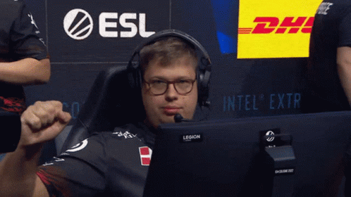 A Man Wearing Headphones And Glasses Sits In Front Of A Dhl Sign GIF