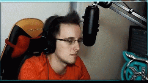 A Man Wearing Headphones And Glasses Sitting In Front Of A Microphone . GIF