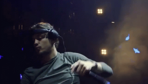 A Man Wearing Headphones And Holding A Microphone GIF