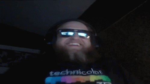 A Man Wearing Headphones And Sunglasses Is Wearing A Technicolor T-Shirt GIF