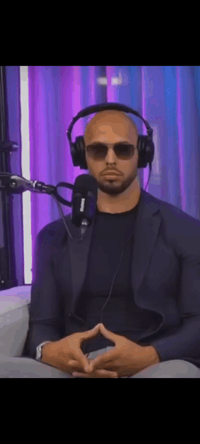 A Man Wearing Headphones And Sunglasses Sitting In Front Of A Microphone . GIF