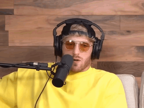 A Man Wearing Headphones And Sunglasses Talking Into A Microphone GIF