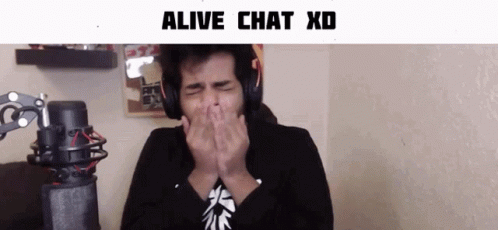 A Man Wearing Headphones Covering His Mouth With His Hands In Front Of A Microphone With The Words Alive Chat Xd Below H GIF