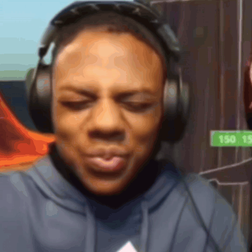 A Man Wearing Headphones Has A Sign That Says 150 15 In The Background GIF