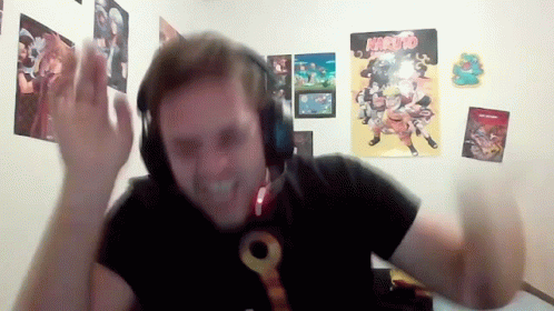 Man With Headphones In Front Of Naruto Posters GIF