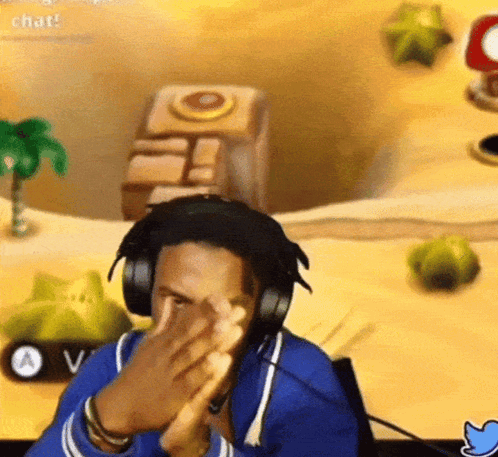A Man Wearing Headphones Is Clapping His Hands In Front Of A Video Game Screen . GIF