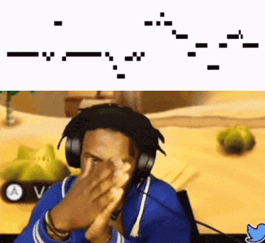 A Man Wearing Headphones Is Covering His Face In Front Of A Computer Screen . GIF