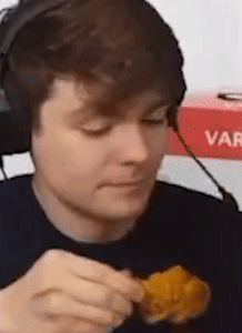 A Man Wearing Headphones Is Eating Chicken Nuggets . GIF