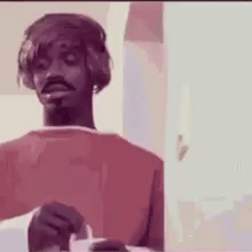 A Man Wearing Headphones Is Holding A Cigarette In His Hand . GIF
