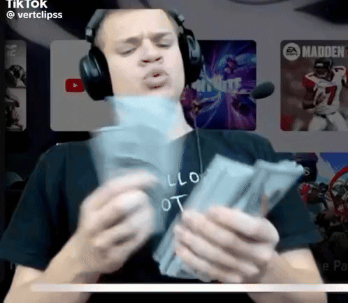 A Man Wearing Headphones Is Holding A Stack Of Money In His Hands GIF