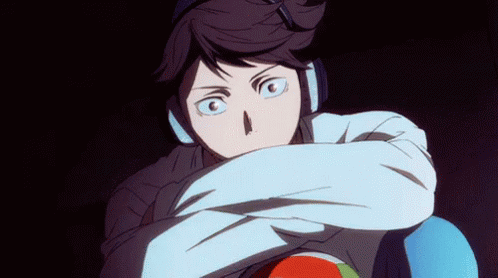 A Man Wearing Headphones Is Holding A Volleyball In His Hands . GIF