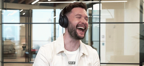 A Man Wearing Headphones Is Laughing And Saying " Yes " GIF