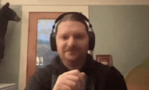 a man wearing headphones is making a fist in front of a bear .