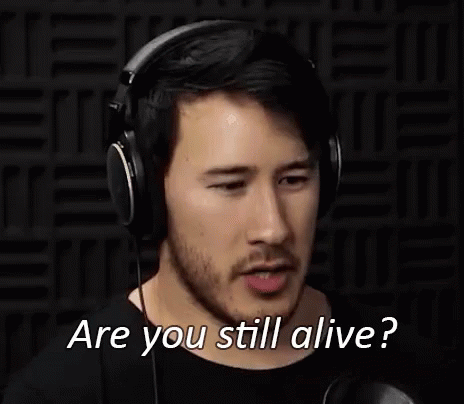A Man Wearing Headphones Is Making A Funny Face And Asking Are You Still Alive . GIF