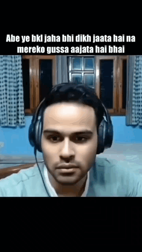 a man wearing headphones is making a funny face while looking at the camera .