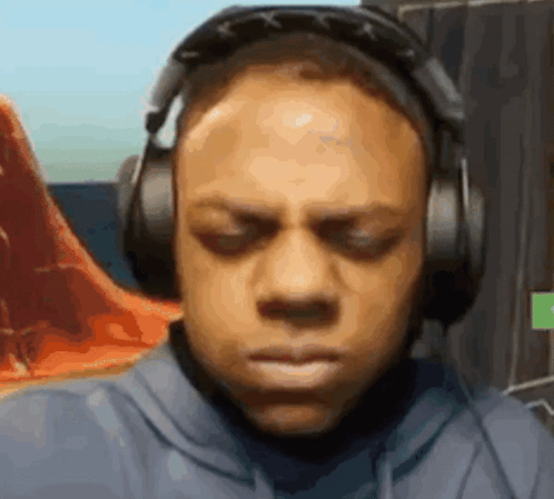 A Man Wearing Headphones Is Making A Funny Face While Playing A Video Game . GIF