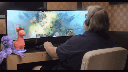 A Man Wearing Headphones Is Playing A Video Game On His Computer GIF