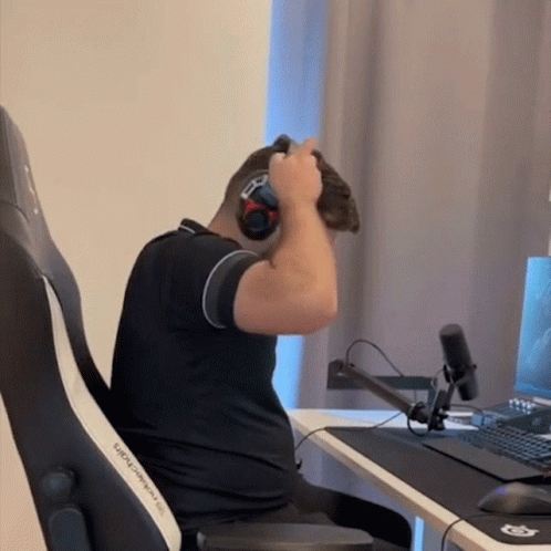 A Man Wearing Headphones Is Sitting In A Black And White Chair GIF