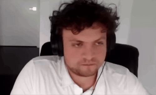 A Man Wearing Headphones Is Sitting In A Chair . GIF