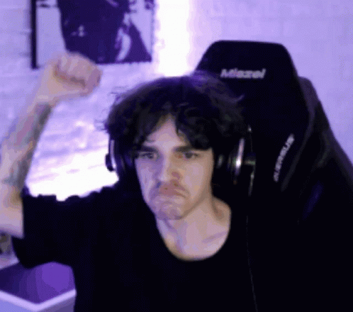 A Man Wearing Headphones Is Sitting In A Chair That Says Miravel GIF