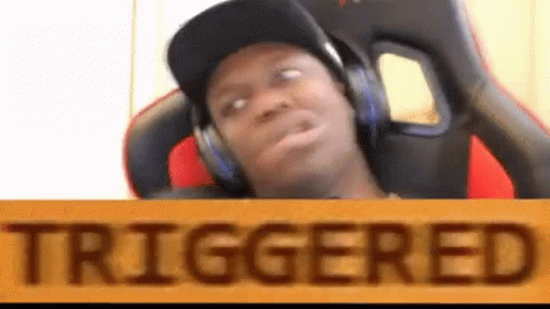 A Man Wearing Headphones Is Sitting In A Chair With A Sign That Says Triggered . GIF