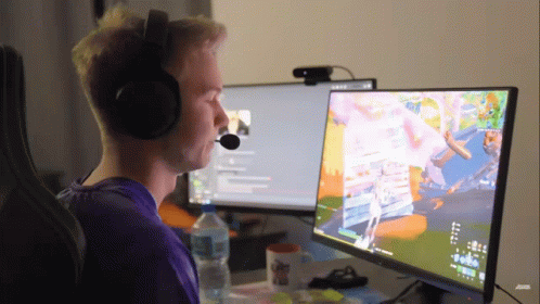 A Man Wearing Headphones Is Sitting In Front Of A Computer Monitor GIF