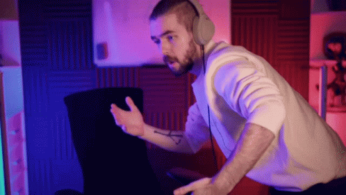 A Man Wearing Headphones Is Sitting In Front Of A Computer Screen GIF