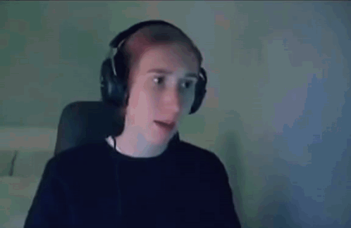 a man wearing headphones is sitting in front of a computer screen .