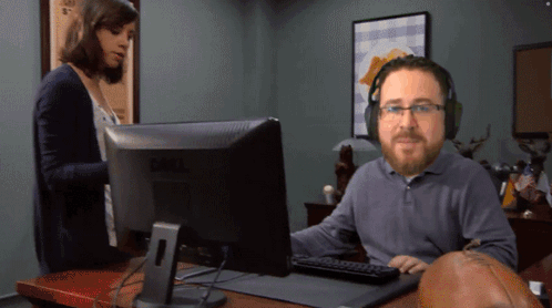 A Man Wearing Headphones Is Sitting In Front Of A Dell Computer GIF
