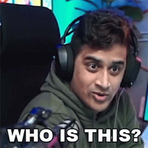 A Man Wearing Headphones Is Sitting In Front Of A Microphone And Making A Funny Face . GIF