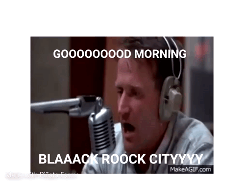 A Man Wearing Headphones Is Sitting In Front Of A Microphone And Saying Good Morning . GIF