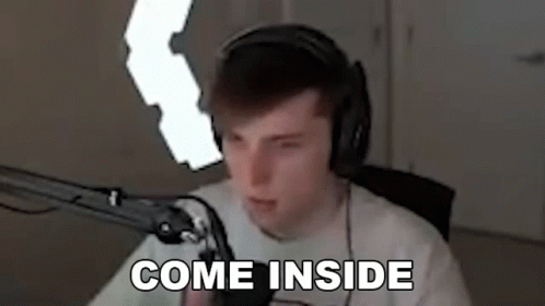 A Man Wearing Headphones Is Sitting In Front Of A Microphone And Says `` Come Inside '' . GIF