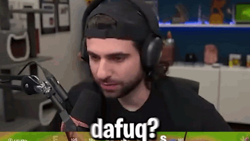 A Man Wearing Headphones Is Sitting In Front Of A Microphone And Talking Into It . GIF