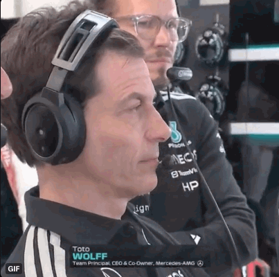 A Man Wearing Headphones Is Sitting In Front Of A Microphone While Another Man Looks On . GIF