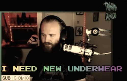 A Man Wearing Headphones Is Sitting In Front Of A Microphone With The Words I Need New Underwear Below Him GIF