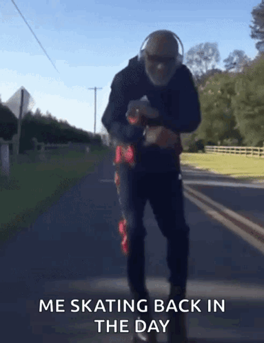 A Man Wearing Headphones Is Skating Down A Road With The Words Me Skating Back In The Day Below Him GIF