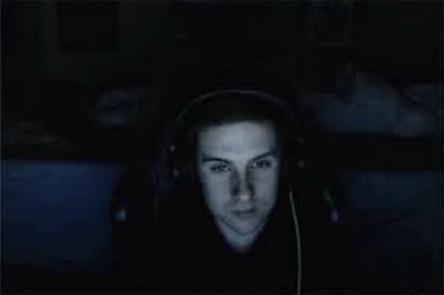 A Man Wearing Headphones Is Smiling And Looking At The Camera GIF