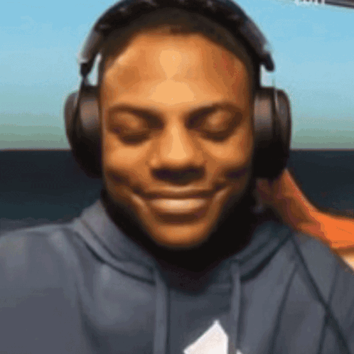 a man wearing headphones is smiling and looking at the camera