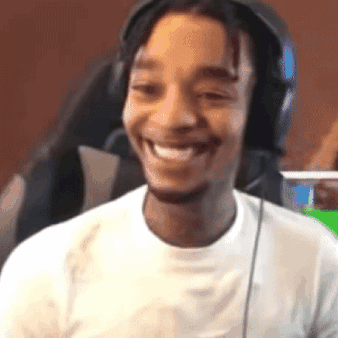 A Man Wearing Headphones Is Smiling And Looking At The Camera . GIF