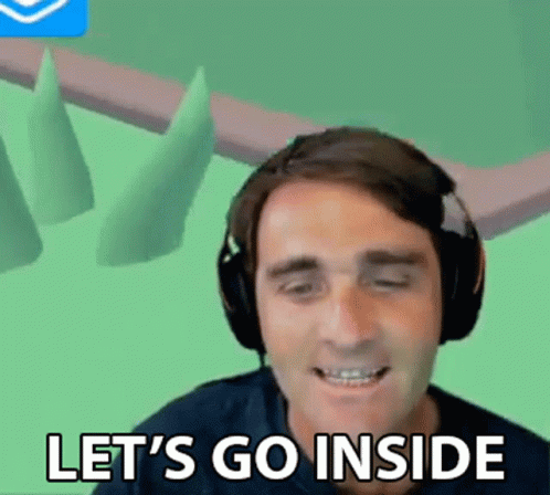 A Man Wearing Headphones Is Smiling And Saying Let 'S Go Inside . GIF